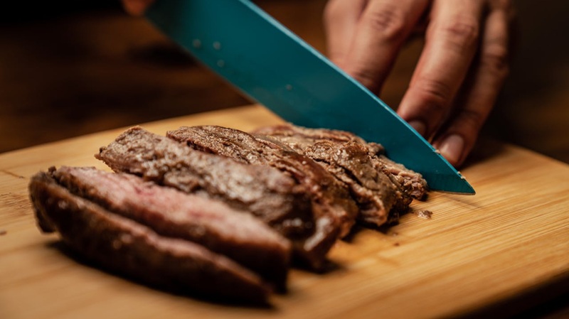 meat being sliced on a butchers block