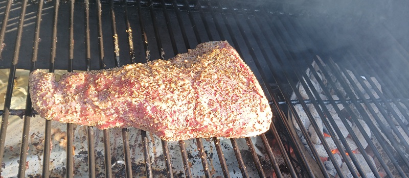 tri tip on the cool side of a charcoal set up for indirect grilling.